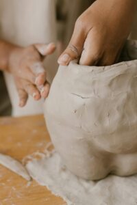 Hands shaping a clay sculpture in a creative pottery workshop. Artistic craftsmanship in focus.